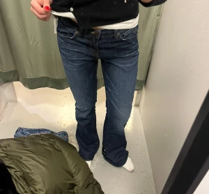 Blå bootcut jeans - Snygga mörkblå jeans från med klassisk bootcut-passform. Jeansen har fem fickor, knapp och dragkedja framtill samt en skön midwaist. Perfekta för dig som gillar en retro vibe och vill ha jeans med lite utsvängda ben.