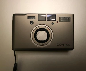 Contax T3 - Contax T3 var och kanske fortfarande är världens bästa analog kompaktkamera. Med sitt Carl Zeiss Sonnar T* 35mm f/2.8-objektiv ger den fantastiska bilder med fint skärpedjup och kontrast även i motljus. Den har avancerad autofokus, manuell fokusering och ljusmätning. Kameran är i fint skick och levereras med kartong och orginal garantisedel. Inköpt på molanders och jag tror banne mig säljaren jobbar kvar. Vill du kolla upp ägarstatus så kan vi gärna ses i butiken med Jalle, världens trevligaste.