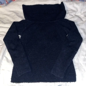 Mörkblå polotröja från Gina Tricot - Snygg mörkblå polotröja från Gina Tricot med bred och mysig krage. Tröjan är stickad och har långa ärmar samt ribbade muddar vid ärmslut och nederkant. Perfekt för dig som gillar enkel och stilren look med extra komfort.Båt ringning typ kan dras ner på axlarna.