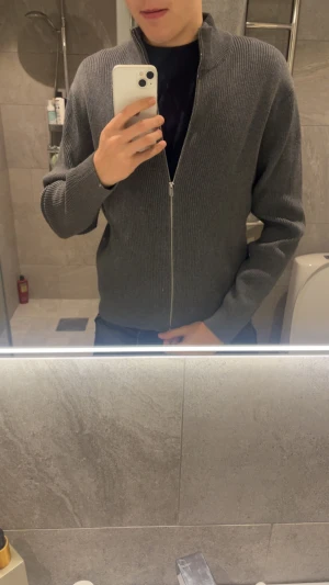 Grå ribbad kofta från Massimo Dutti - Säljer en stilren grå kofta från Massimo Dutti i storlek S. Koftan är ribbstickad, har lång ärm och hel dragkedja framtill. Materialet är 100% bomull vilket gör den både mjuk och skön. Perfekt för dig som gillar enkel och clean look. 10/10 skick. Priset ej hugget i sten!