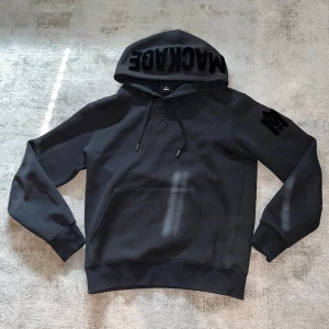 Svart hoodie från Mackage - Säljer en svart hoodie från Mackage med stor logga på huvan och ett M på ärmen. Tröjan har känguruficka framtill, dragsko i huvan och ribbade muddar. Skick 8/10, köpt för 3800kr!