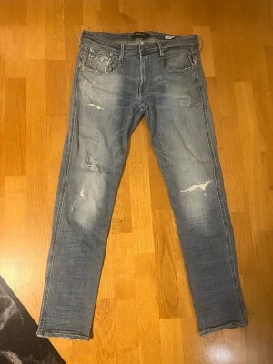 Replay Anbass - Replay Anbass jeans i ljusblå tvätt med slitningar.  Äldre modell köpta 2014. Har bara legat i min farsas garderob sen dess o blivit bortglömda😅Använda ett fåtal gånger bara. Storlek 32/32