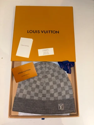 LV mössa grå - Hej säljer ni min lv mössa i färgen grå. Riktigt snygg och fräsh mössa. Helt ny. Aldrig använd. Perfekt nu till vinter.