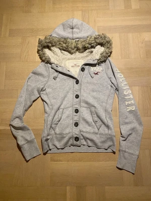 Hollister cardigan vintage - Jag säljer en riktigt cool cardigan från hollister som är väldigt svår att få tag på🤩 Den har en fin päls! || Skick: 9,5/10 ||Storlek: S men passar också mindre || Modellen är 178cm🙌 || Tveka inte på att ställa frågor😉