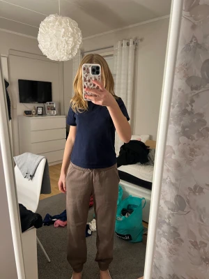 Bruna mjukisbyxor från Lindex - Bruna mjukisbyxor från Lindex med elastisk midja och snörning. Byxorna har ribbade muddar vid bensluten och är tillverkade i mjukt, fleeceliknande material på insidan. Perfekta för chill dagar och har en loose passform. Aldrig använda mer än 3gånger 