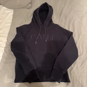 Hoodie från Gant W - Fin blå hoodie från märket Gant med en tryck i mitten av hoodien. Storlek S från damsidan men funkar för killar också. En liten defekt på sidan av ärmen av bläck, vet ej om de går bort. Pris går att diskuterar.