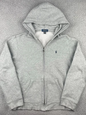 Grå hoodie från polo Ralph lauren  - Säljer en fin hoodie från polo Ralph lauren. Bra skick, möjligtvis något urtvättad. Skickar snabbt efter att du har gjort din beställning. Har du några frågor? Skicka ett meddelande👍 XL= ca S