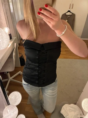 Svart korsett-topp med snörning - Snygg svart korsett-topp med snörning framtill 