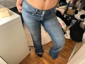 90s bootcut jeans blå - Säljer ett par klassiska 90sbootcut jeans i blå tvätt med bootcut-snitt och låg midja. Jeansen har fem fickor, knapp i bakfickorna. Obs har minimalt slitage längst ner!!!