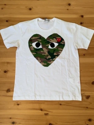 Comme des Garçons t-shirt  - Säljer denna vita t-shirt från Comme x bape i storlek M. Skick 9/10 använd mycket sparsamt. Vid andra frågor eller funderingar tveka inte på att fråga. 