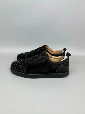 Christian Louboutin Louis Junior Spikes Sneaker Svart - • The shoes are used but still in good condition  • Size: 40.5 (fits 41–41.5)  • Color: Black  • Retail price: 9500 SEK / 795€  • No accessories   Additional info: heel patches has been added inside both heels