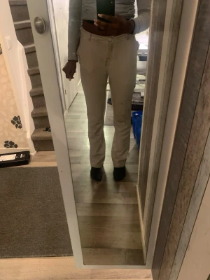 Beige raka kostymbyxor - Snygga beige kostymbyxor med rak passform och midwaist. Byxorna har klassiska fickor fram och bälteshällor i midjan. Perfekta för dig som gillar stilrena och enkla plagg. Materialet känns mjukt och har en lätt stretch för extra komfort. Har bruna märken och fläckar!