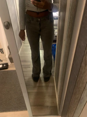 bootcut jeans - Säljer ett par gråa jeans med bootcut passform och klassisk femficksdesign. Jeansen har låg midja och är tillverkade i ett mjukt bomullsmaterial. Perfekta för dig som gillar en avslappnad men ändå snygg look.