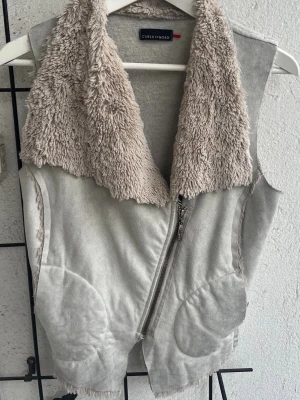 Mockaväst - Carla Du Nord - Supersnygg väst i ull, päls och mocka.  Västen har en baksida i varm ull, snygg mocka framsida med pälskrage och päls insida framtill.  Västen har inga fläckar eller märken och är i ett väldigt bra skick.