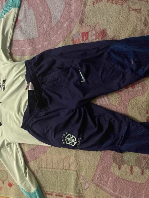 Ingen sko syns på bilderna - Bilderna visar ett Brasilien Nike träningsset med tröja och byxor, men inga skor är synliga eller till salu på dessa bilder.