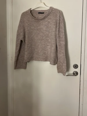 Beige/rosa  stickad tröja  - Mysig beige stickad tröja med rund hals och ribbade muddar. Modellen är loose fit och har långa ärmar. Perfekt för lager-på-lager under kyliga dagar. Enkel och stilren design som funkar till jeans eller kjol. Pris kan diskuteras och tvätt ingår     