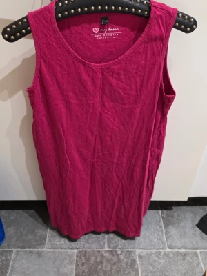 Mörkrosa linnetopp från bpc - Säljer en enkel och snygg mörkrosa linnetopp från bpc bonprix collection. Toppen är ärmlös med rund halsringning och tillverkad i 100% bomull, vilket gör den mjuk och skön att bära. Perfekt för varma dagar och enkel att matcha med jeans eller shorts.