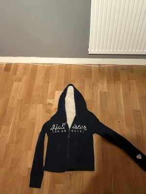 Hollister hoodie - En liten schysstare hoodie ifrån hollister.inga tecken på skador. Med ull på insidan , otroligt bra nu för vintern . Säljes pga att den är förliten för mgi 