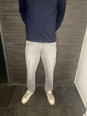 Jack & Jones Jeans - Säljer ett par gråa Jack & Jones jeans med klassisk femficksdesign och raka ben. 