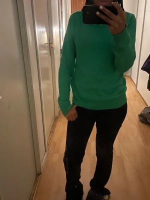 Grön stickad tröja från VILA - Snygg grön stickad tröja från VILA med rund hals och ribbade muddar vid ärmslut och nederkant. Tröjan har en klassisk, enkel design och är långärmad, perfekt att matcha med jeans eller kjol. Passar dig som gillar färg och vill ha en mjuk och skön vardagströja.
