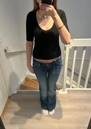 Svart ribbad v-ringad T-shirt från Kappahl  - Säljer en snygg svart ribbad v-ringar T-shirt från Kappahl i storlek xs! Perfekt för skapa en mängd olika outfits!✨Har kommit till användning fåtal gånger. Djur och rökfritt hem!  Bra att veta: * Märke: Kappahl * Färg: Svart * Storlek: XS * Material: 50% Viskos, 28% Polyester och 22% Polyamid * Skick: Mycket bra  Detaljer: * Sparsamt använd, inga defekter eller liknande! * Klassisk passform som är bekväm och lätt att matcha. * Perfekt för en avslappnad look.