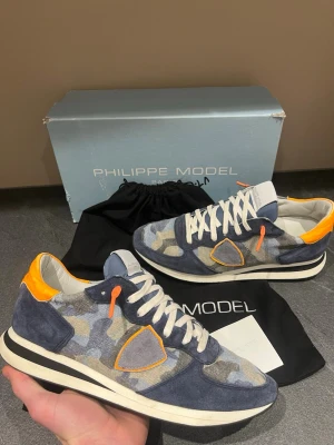 Philippe Model trainers - Snygga blåa camo Philippe model trainers. Nästam ny skick, inga defekter 9/10. Stor storlek 41 snarare 42. Box och dustbag medföljer!