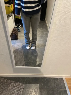 Grå bootcut jeans från Gina Tricot - Snygga grå jeans från Gina Tricot. De har bootcut-ben, klassisk femficksdesign och hög midja. Jeansen är tillverkade i ett mjukt denimtyg och har en stilren, tvättad grå färg som passar till det mesta.