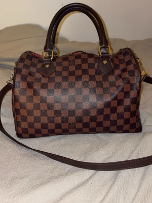 Väska dam - En väldigt fin handväska, är i färgen brun och har guldiga detaljer. Använd ett par gånger och är i bra skick. Dragskedjan är tyvärr sönder men går enkelt att fixa hos en skräddare, i övrigt är väskan i väldigt bra skick. Inga skador på väskan eller missfärgningar 