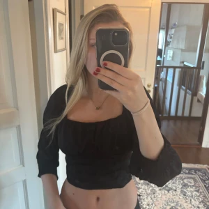 Svart croppad blus med puffärm - Trendig svart croppad blus med långa puffärmar och fyrkantig urringning. Passar mig som har 36