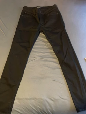 Svarta Jack & Jones  jeans i stretch - Snygga svarta Jack & Jones  jeans med klassisk femficksmodell och smal passform. Jeansen har stretchigt material för extra komfort och en stilren look som passar till det mesta.