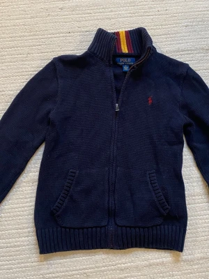 Polo Ralph Lauren kofta - Snygg polo Ralph Lauren kofta i en marinblå färg. Barnstorlek M (10-12). Det är min lillebrors, så den är köpt på killavdelningen, men passar tjejer också
