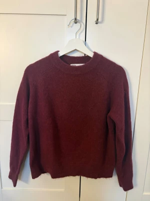 Stickad tröja  - Mysig vinröd stickad tröja från Zara med rund halsringning i storlek S. Endast använd ett par få gånger!