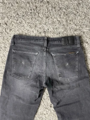 Grå jeans från Nudie Jeans - Säljer ett par gråa jeans från nudie jeans. Storleken på jeansen är W30 och L32. Passformen heter skinny lin. Nypris ligger på cirka 1699kr!