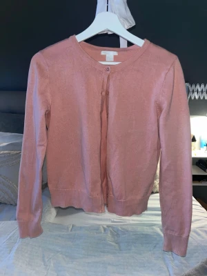 Rosa stickad kofta – Y2K / coquette / basic - Söt rosa stickad kofta 💕 Superfin färg, passar till allt och sitter jättebra! I gott skick, inga fläckar eller hål. Perfekt till vår/sommar 🌸 Storlek: S (sitter croppad)