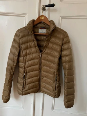 Beige Moncler dunjacka  - Rensar ut lite inför flytt och säljer en beige Moncler dunjacka i storlek S som inte längre används. Nytvättad och mycket fint skick.