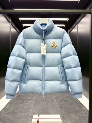 Ljusblå pufferjacka från Moncler - Snygg ljusblå pufferjacka från Moncler med hög krage och quiltad design. Jackan har dragkedja framtill, två sidofickor och Moncler-logga på bröstet. Perfekt för kalla dagar och ger en trendig look.