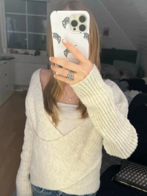  Stickad omlott  tröja från NA-KD - Säljer en jättesöt beige ribbstickad tröja från NA-KD💘Tröjan har en bred v-ringning och långa ärmar. Tröjan har en avslappnad passform och är tillverkad i mjukt material, perfekt för lager på lager.                                 Pris kan diskuteras💘💓