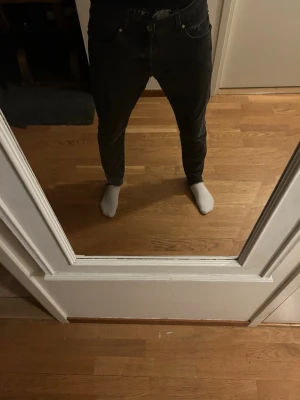 Svarta relaxed jeans med rå kant - Säljer ett par svart gråa jeans från tiger of Sweden som är rätt så relaxed passform med råa kanter vid bensluten