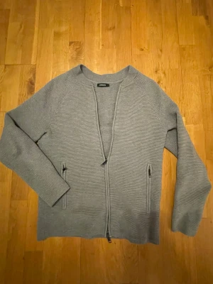 Grå fullzip från J.Lindeberg i storlek S - Säljer en stilren grå kofta från J.Lindeberg med diskreta ränder och hel dragkedja framtill. 😊Storlek S! Bara att skriva vid frågor, pris går att diskuteras 🙌