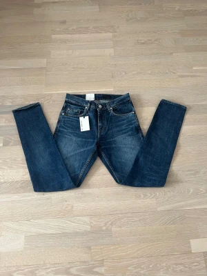 Blå tiger of sweden jeans i W29 L34 - Snygga blå jeans med klassisk femficksdesign och slimmade ben. Perfekta för dig som gillar en tidlös och clean look.