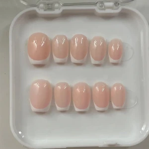 Fransk manikyr lösnaglar - Snygga lösnaglar med fransk manikyr i en naturlig rosa ton och vita toppar. Perfekt för en elegant look. Kommer i en praktisk förpackning med flera storlekar för att passa olika naglar.