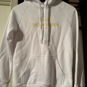  Peak Performance hoodie - Vit hoodie med guldig Peak text, aldrig använd fint skick! 