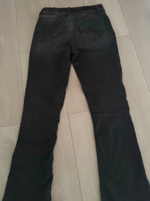 Gråa lågmidjade bootcut jeans från LTB - Säljer ett par gråa/svarta jeans från LTB med klassisk bootcut passform. Jeansen har låg midja och är tillverkade i ett mjukt bomullsmaterial med lite stretch för extra komfort. 