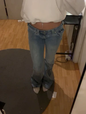 Ljusblå bootcut jeans True Religion - Säljer ett par ljusblå bootcut jeans från True Religion i storlek w24 dom är låg midjade pytte små hål vid knät som inte syns så mkt om du inte böjer på knäna rätt så sönder trampade pris kan diskuteras vid snabb affär 