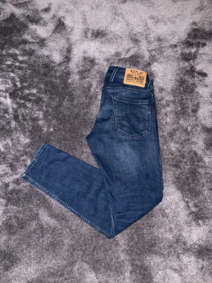 Replay Anbass Jeans - Snygga blå jeans från Replay med klassisk femficksdesign och läderpatch bak i midjan. Jeansen är i Anbass moddellen och har en slim passform och är tillverkade i mjukt denimtyg. Perfekta för en avslappnad och trendig look.