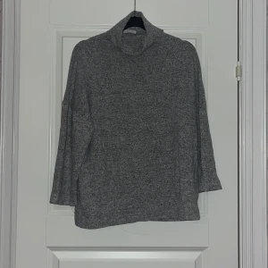 Grå polotröja från Stradivarius  - Mysig gråmelerad polotröja från Stradivarius i storlek S. Tröjan har polokrage och är tillverkad i ett mjukt material. 