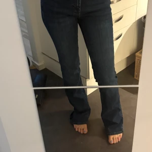 Mörkblå bootcut jeans med detaljer - Snygga mörkblå jeans med bootcut passform och medel hög midja. 