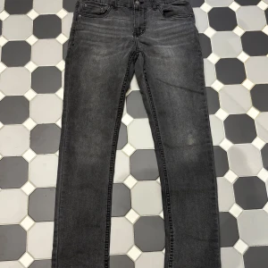 Levi's 512 Slim Taper svarta jeans - Svarta Levi's 512 Slim Taper jeans med klassisk femficksdesign och smal passform som smalnar av nedtill. Jeansen har en mörk tvätt och är tillverkade i mjukt denimtyg. Perfekta för dig som gillar en stilren och modern look.