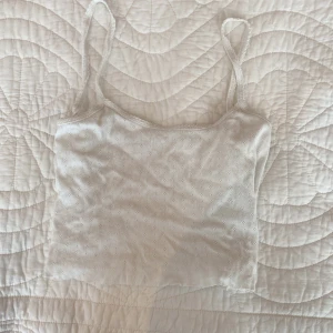 Vit ribbad linnetopp från Oysho - Supersöt vit linnetopp från Oysho med smala axelband och ribbad struktur. Toppen har små broderade hålmönster över hela tyget som ger en extra detalj. Perfekt till sommaren och enkel att matcha med allt. Kan ksk förhandla om pris 