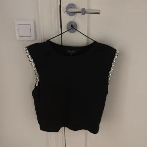 Svart ärmlös topp med detaljer - Super fin tröja som jag köpte i Los Angeles, men säljer nu på grund av att jag inte använder den. 💓💓